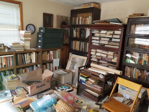Photo of a room full of bookcases packed with books, newspapers, magazines, index files, and other materials